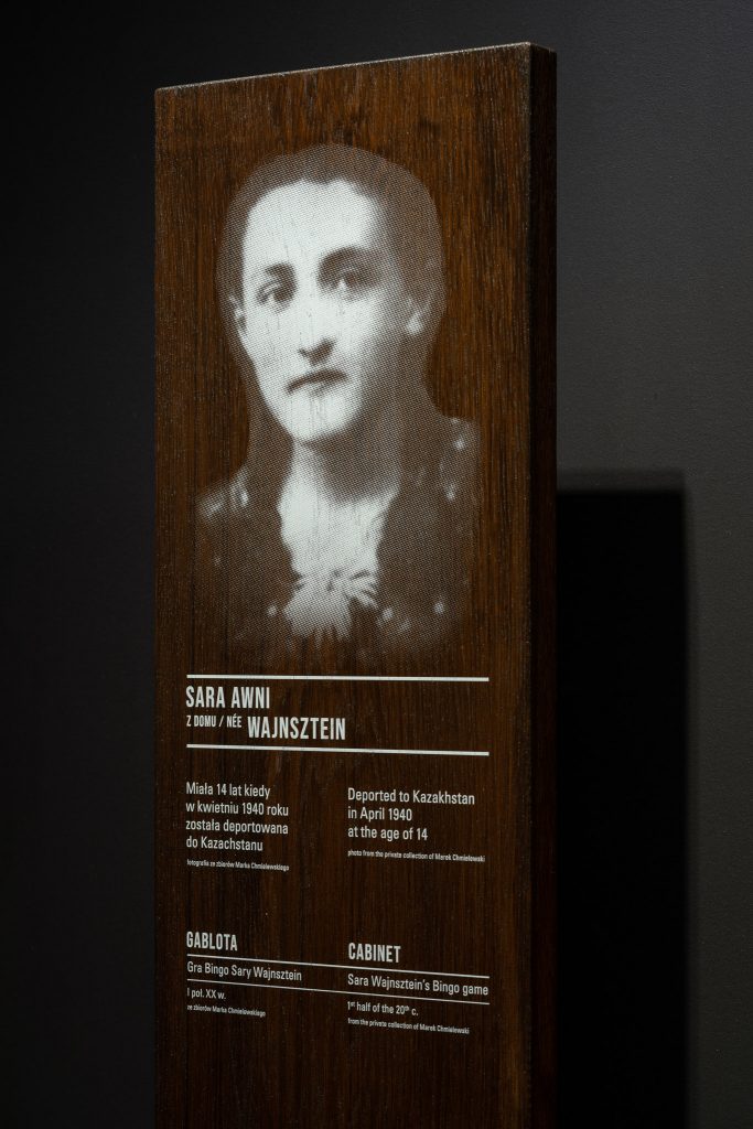 Fragment wystawy stałej, portret kobiety wygrawerowany w drewnie.