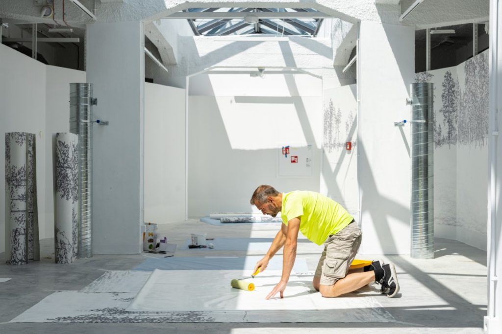 Zdjęcie przedstawia wykonywanie prac podłogowych w pomieszczeniu wystawy stałej.