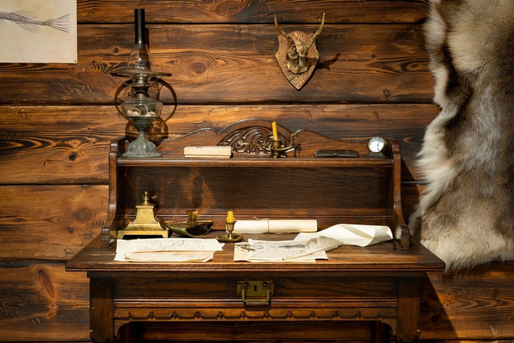 Zdjęcie przedstawia drewniane biurko. Jeden z wielu eksponatów.