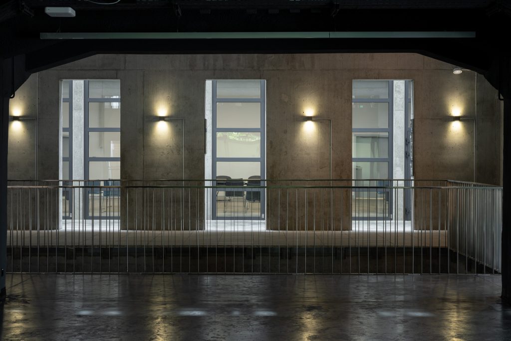 Zdjęcie przedstawia oszklone wejście na salę konferencyjną wewnątrz budynku Muzeum.