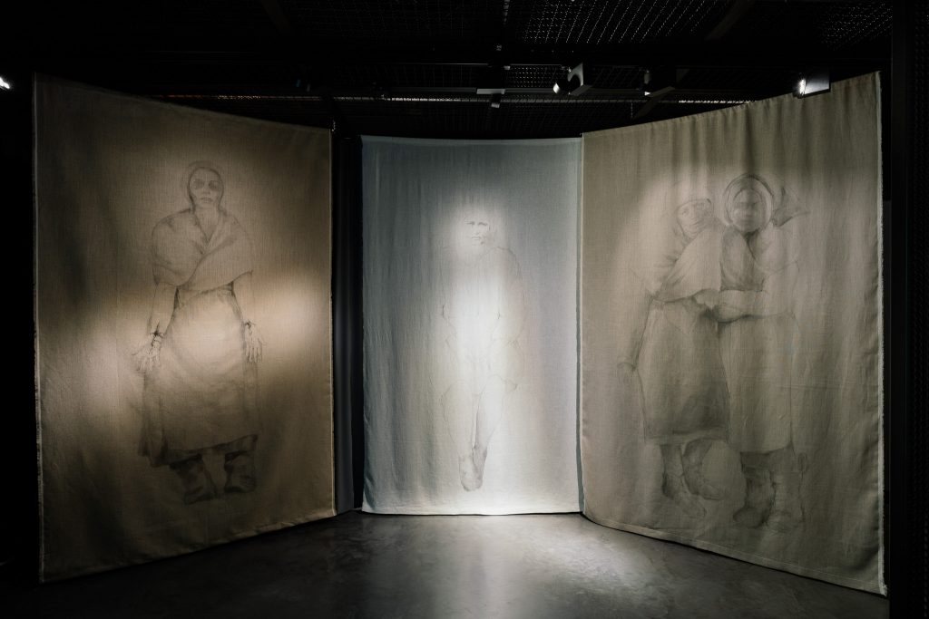 Wystawa czasowa "Tylko ból jest mój" w Muzeum Pamięci Sybiru. Podświetlone płótna z malarskimi przedstawieniami kobiet na Sybirze.
