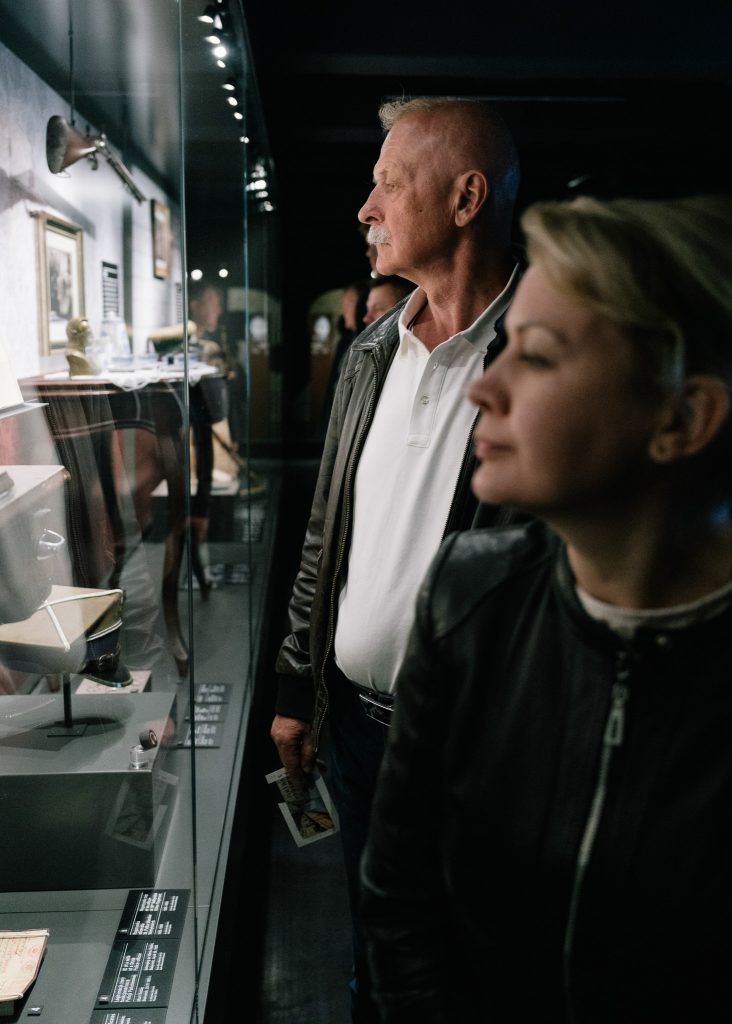 Zwiedzający przyglądają się eksponatom w gablotach na wystawie stałej Muzeum Pamięci Sybiru.