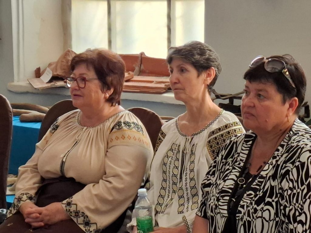 Trzy kobiety siedzą i skupione patrzą przed siebie.