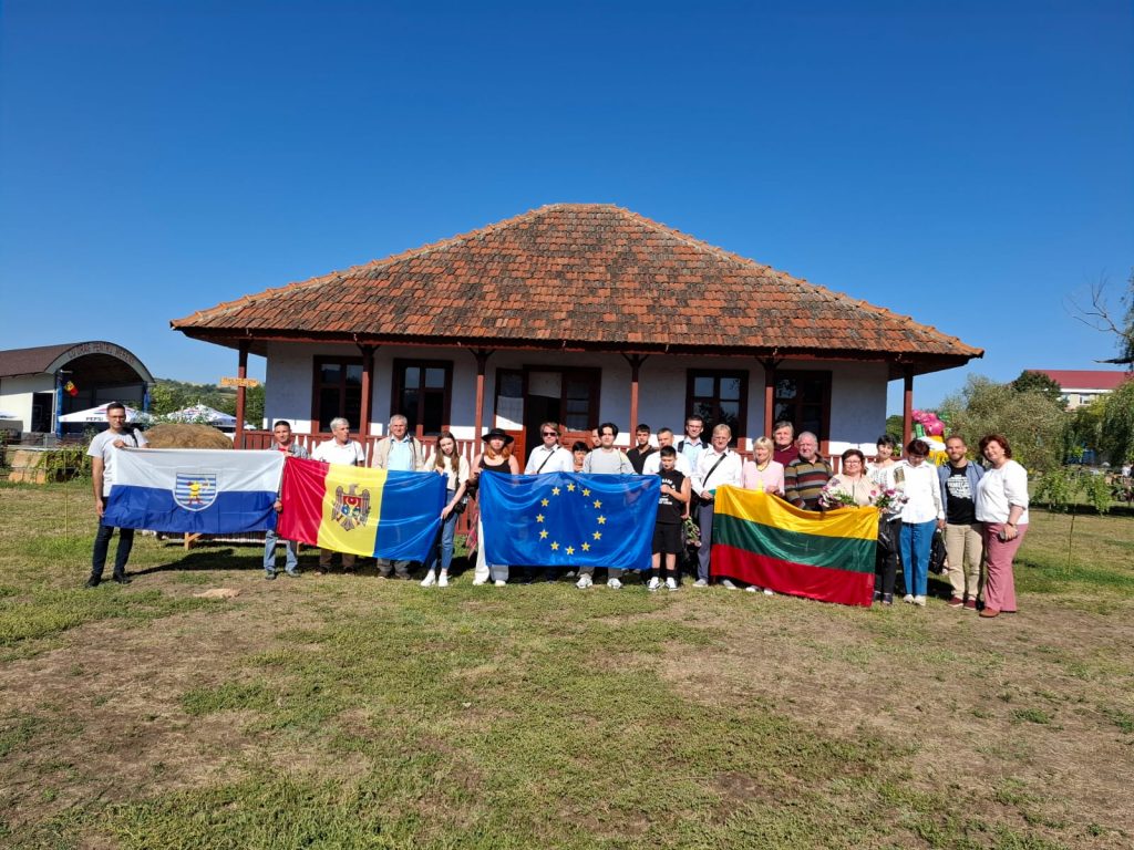 Grupa uczestników Peletonu trzyma cztery flagi. Od lewej są to flagi: Mołdawii,