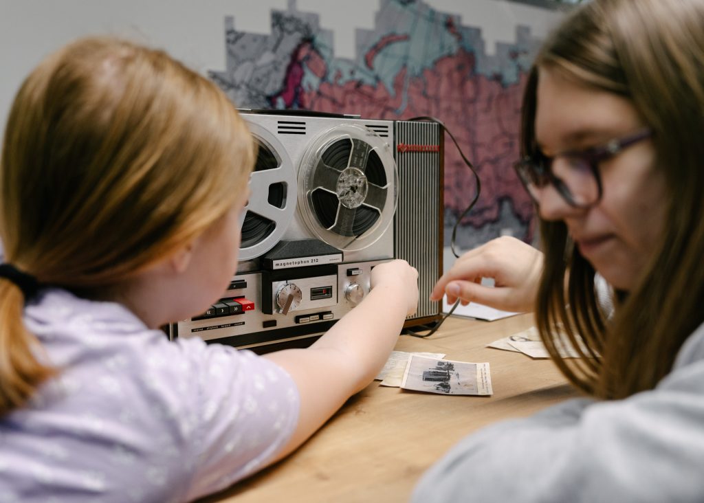 Dwie dziewczynki siedzą przy magnetofonie