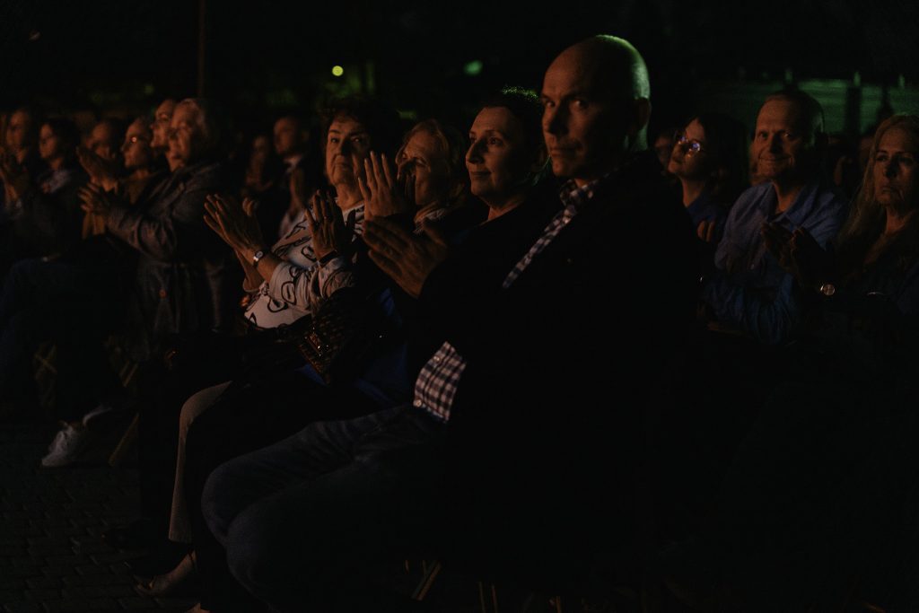 Widzowie oglądając spektakl biją brawo.
