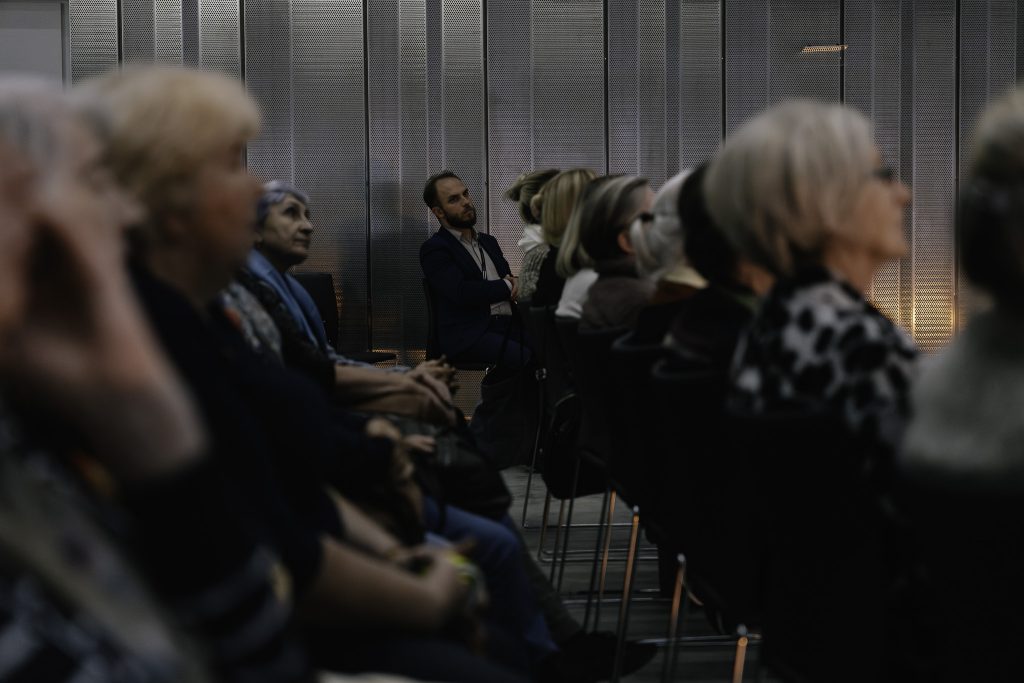 Grupa osób słucha wykładu.