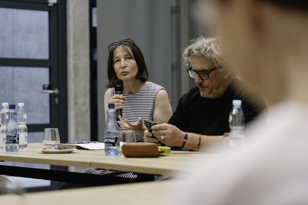 Dr Tatiana Misijuk przemawia przy stole. Obok niej siedzi Prof. Jarosław Perszko.