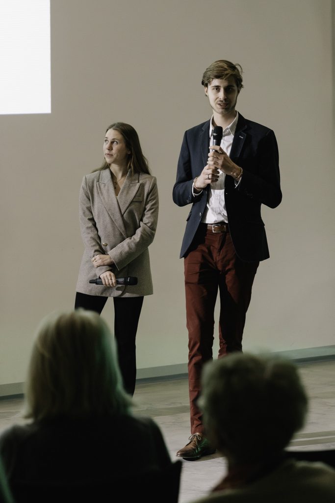 Paweł Gniado przemawia. Trzyma w rękach mikrofon. Obok niego stoi Natalia Mika.