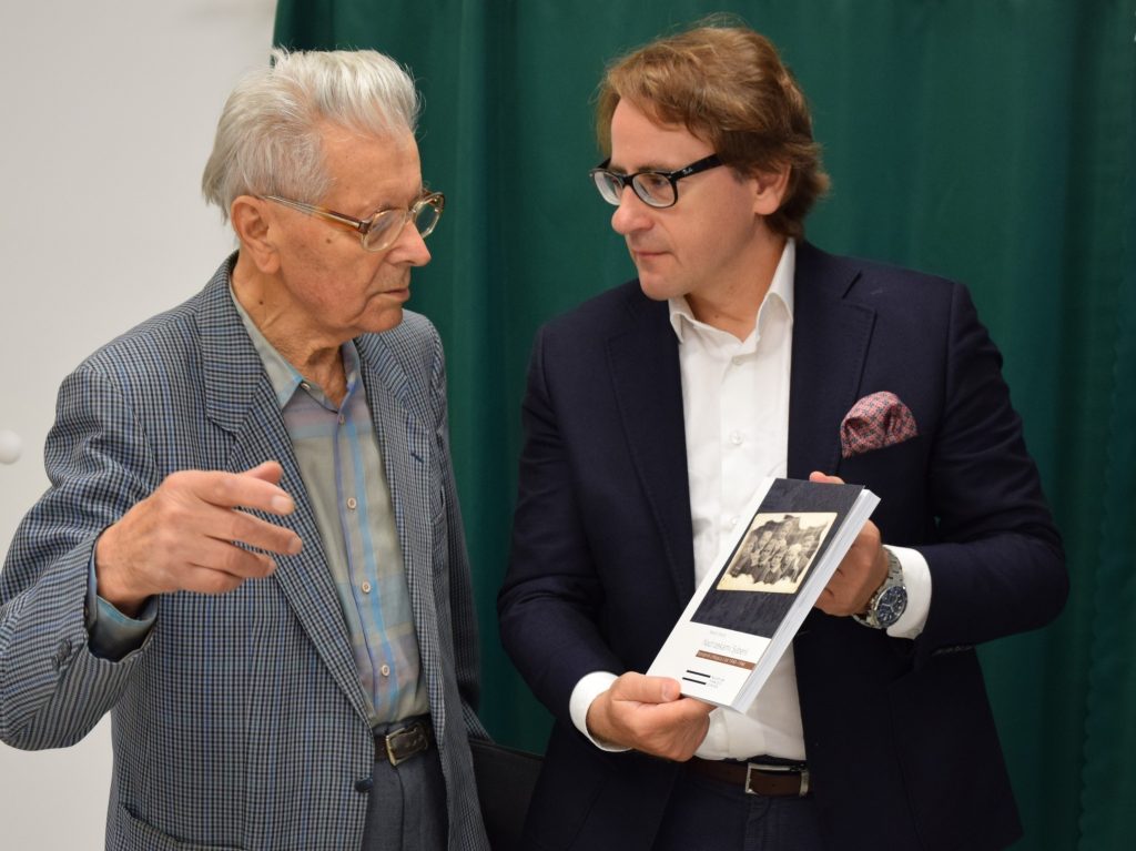 Marian Stecyk rozmawia z prof. Wojciechem Śleszyńskim, dyrektorem Muzeum Pamięci Sybiru. Dyrektor trzyma książkę autorstwa Mariana Stecyka i prezentuje ją autorowi.