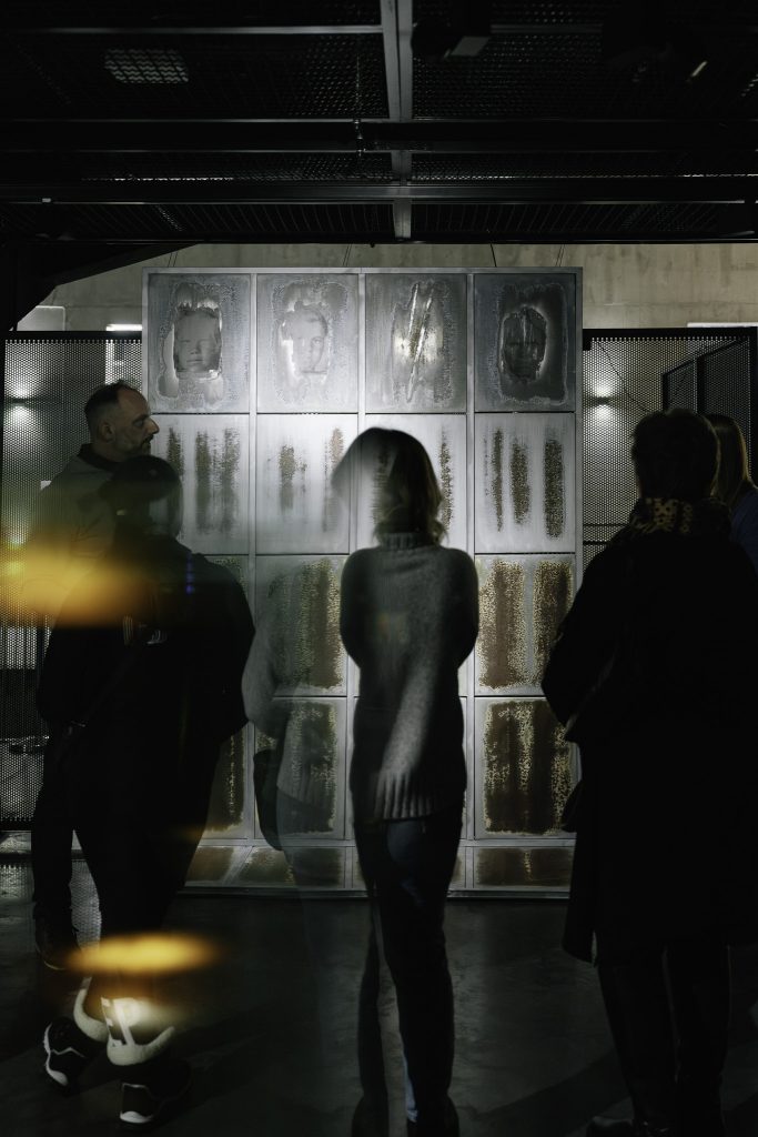 Grupa kilku osób zwiedzających wystawę ogląda jeden z eksponatów.