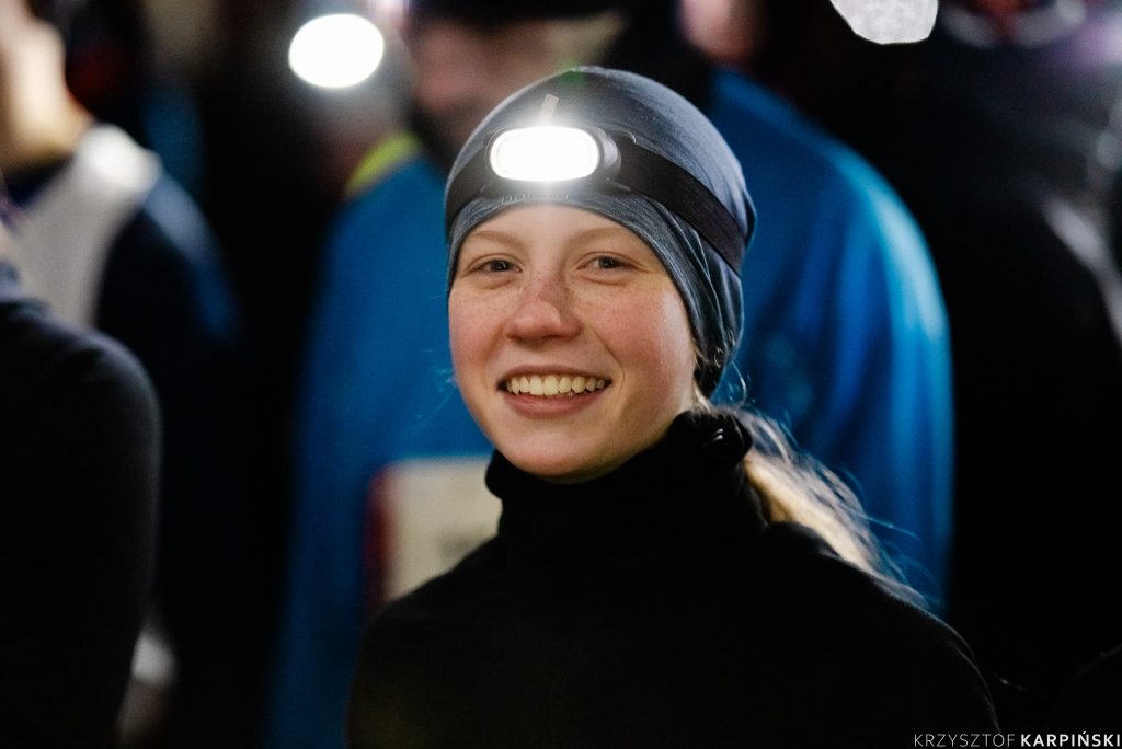 Młoda uśmiechnięta dziewczyna w czarnym golfie, Ma włączona czołówkę.