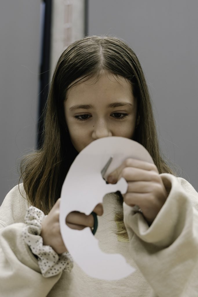 Dziewczynka w jasnej bluzie wycina