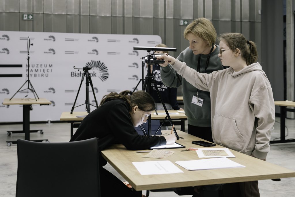 Kobieta w zielonej bluzie z identyfikatorem na szyi sto