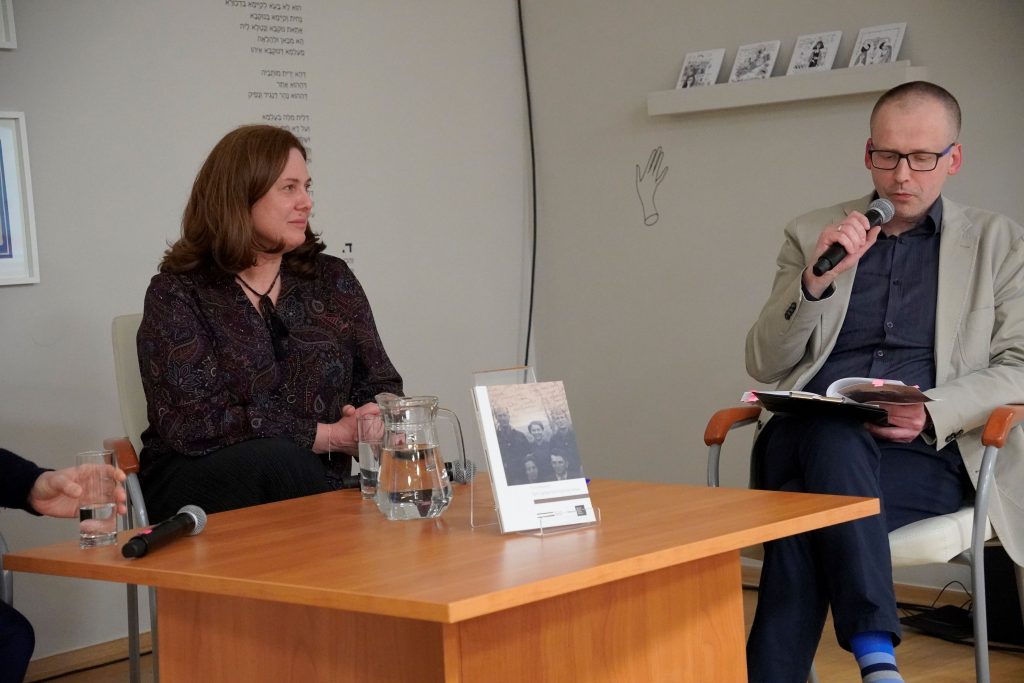 Przy stoliku siedzą: Anna Pyżewska z Działu Naukowego – Instytutu im. Seweryna Nowakowskiego Muzeum Pamięci Sybiru oraz dr Marcin Zwolski, kierownik działu naukowego Muzeum Pamięci Sybiru. Dr Marcin Zwolski przemawia do zgromadzonych osób. Czyta fragment książki.