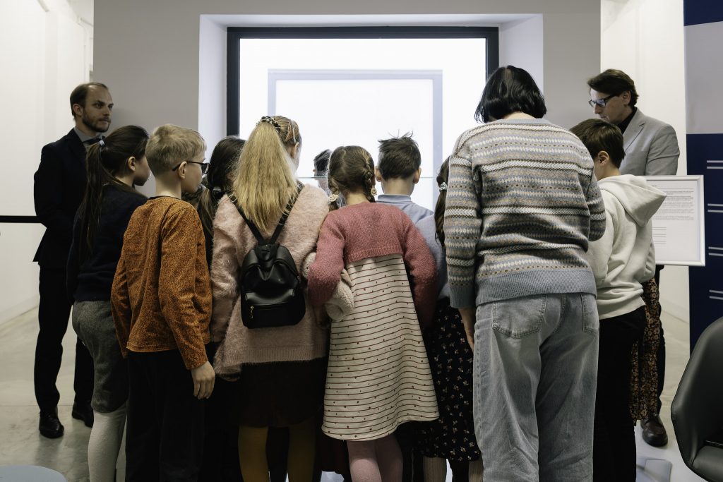 Grupa dziecki otacza gablotę z eksponatem miesiąca. Wśród nich jest wnuczka