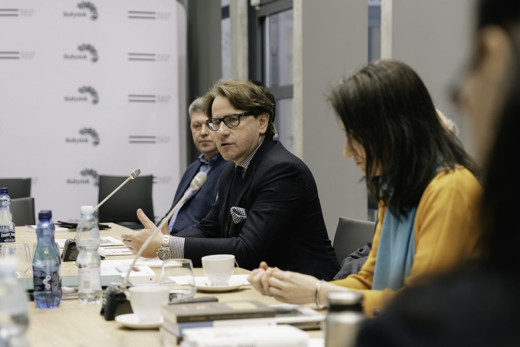 Prof. Wojciech Śleszyński przemawia do zebranych uczestników Komisji Syberyjskiej. Przed nim, na stole, znajduje się mikrofon. Wszyscy uczestnicy siedzą przy stole.