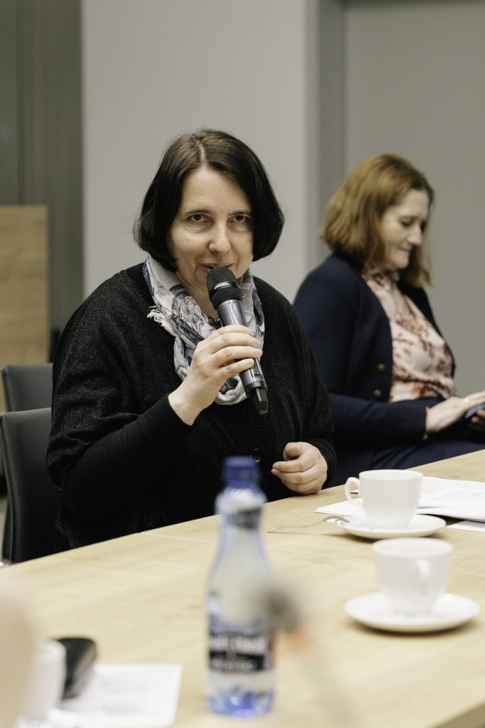 Jedna z uczestniczek wydarzenia przemawia. Trzyma w ręku mikrofon.